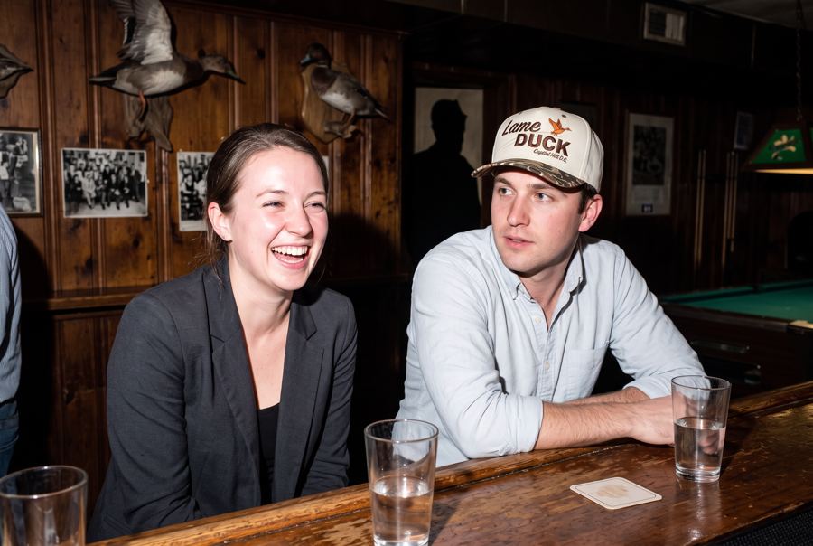 Two staffers at a wood-paneled dive bar with taxidermy ducks